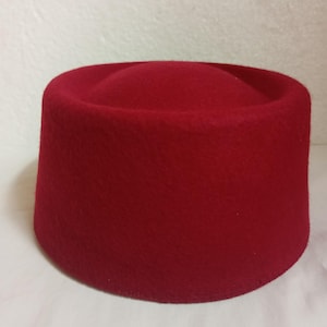 Peut inclure: Un fez en feutre rouge.