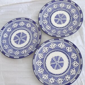 Peut inclure: Trois assiettes en céramique bleu et blanc avec un motif géométrique. Les assiettes ont un centre blanc avec un motif en étoile bleue et une bordure bleue avec un motif géométrique répété.