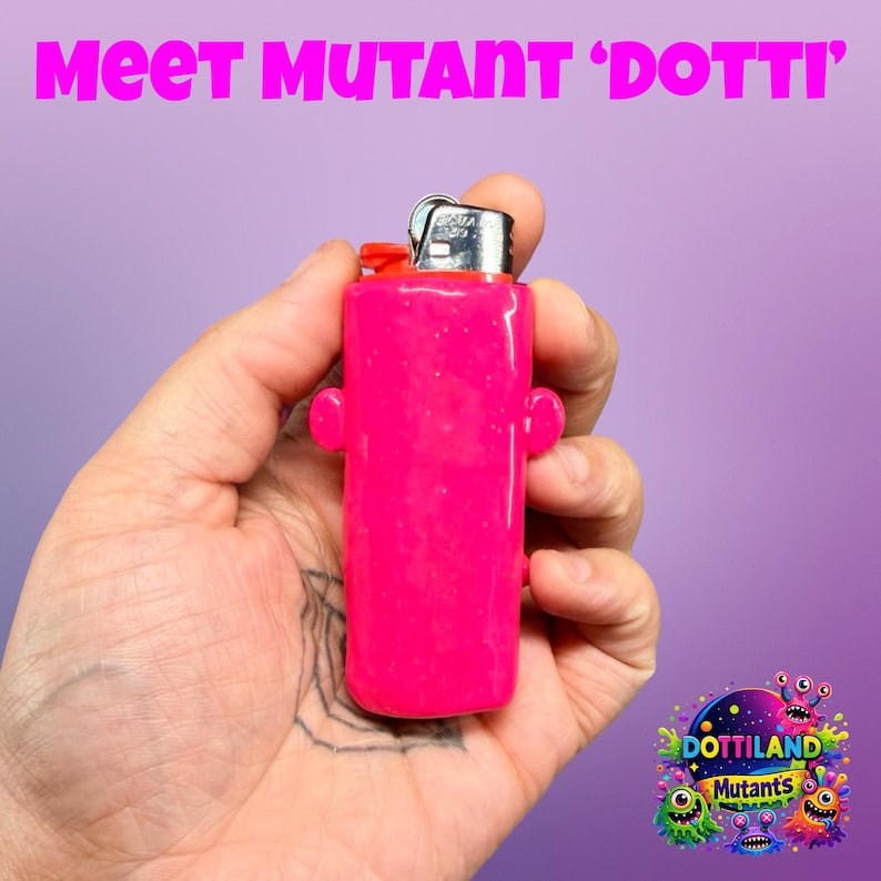 May include: A vibrant pink lighter with a red top and silver metal details. The lighter features two small, rounded side protrusions. The text "Meet Mutant 'Dotti'" is visible above the lighter.