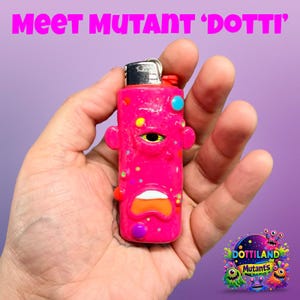 May include: A pink lighter with a cartoon face design, held in a hand. The lighter has a silver top and is decorated with colourful spots and shapes. The text "Meet Mutant 'Dotti'" is at the top.