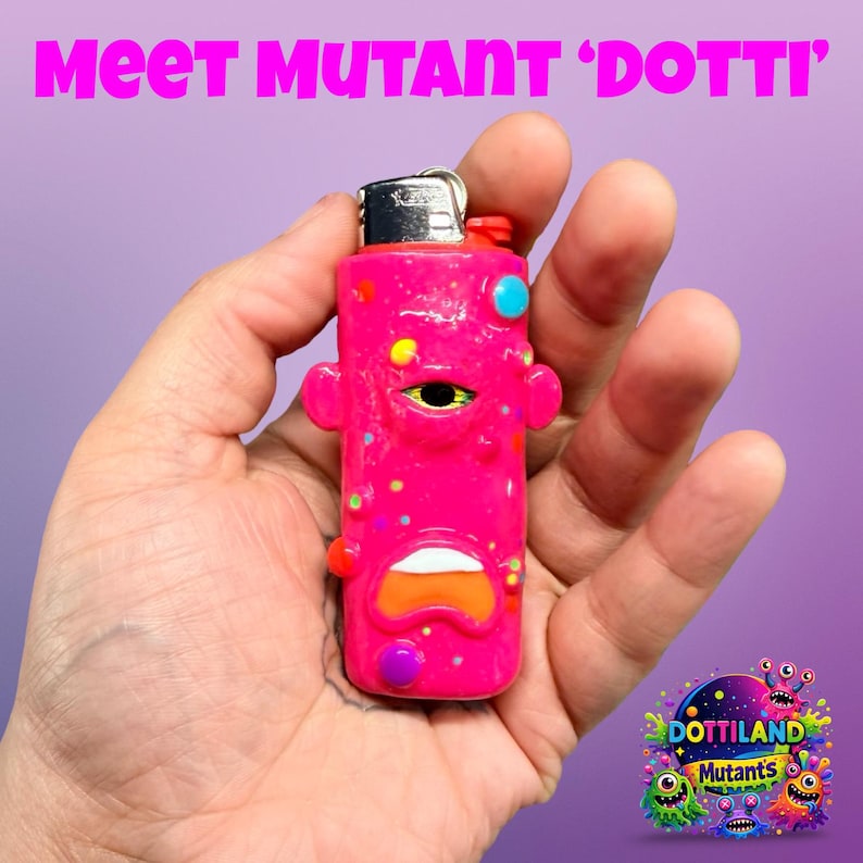 May include: A pink lighter with a cartoon face design, held in a hand. The lighter has a silver top and is decorated with colourful spots and shapes. The text "Meet Mutant 'Dotti'" is at the top.