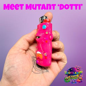 May include: A vibrant pink lighter with a quirky face design, a red top, and colourful details. The text "Meet Mutant 'Dotti'" is above the lighter. A colourful "Dottiland Mutants" logo is in the bottom right corner.