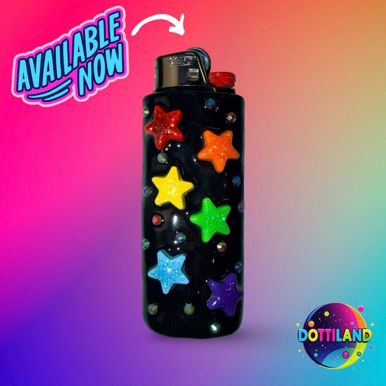 May include: Black lighter decorated with colorful star-shaped embellishments. The stars are red, orange, yellow, green, blue, and purple. The lighter has the text "AVAILABLE NOW" and the logo "Dottiland".