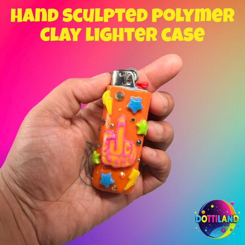 May include: Hand-sculpted polymer clay lighter case in orange, decorated with blue stars, green stars, yellow lightning bolts, and a pink and orange hand gesture. The text "HAND SCULPTED POLYMER CLAY LIGHTER CASE" is at the top.