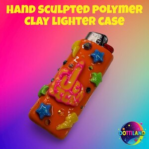 May include: Hand-sculpted polymer clay lighter case in orange with a raised middle finger design in pink and yellow. The case is decorated with blue stars, green stars, yellow lightning bolts, and rhinestones. The text "HAND SCULPTED POLYMER CLAY LIGHTER CASE" is at the top.