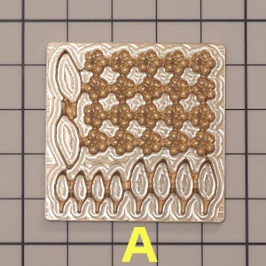 Könnte beinhalten: Eine Metallform mit einem dekorativen Muster aus kleinen Kreisen und einem Blattdesign am Boden. Die Form ist silberfarben mit einem goldfarbenen Muster.