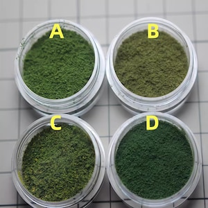 May include: Four small jars of green powder labeled A, B, C, and D. The powder in each jar has a slightly different shade of green.