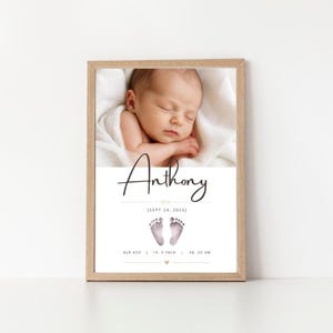 May include: A framed print featuring a photograph of a sleeping newborn wrapped in a white blanket. Below the photo, the name Anthony is printed in black script, followed by the date SEPT 24, 2026, two small footprints, and 8LB 4OZ | 19.5 INCH | 08:00 AM.