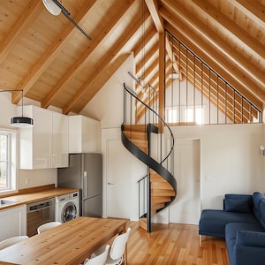 Può includere: Vista interna di una casa moderna con una scala a chiocciola in legno, pavimenti in legno e un soffitto inclinato con pannelli di legno. La cucina è dotata di mobili bianchi, un frigorifero in acciaio inossidabile e un tavolo da pranzo in legno. Un divano blu si trova nella zona giorno.