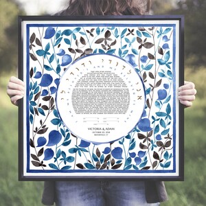 May include: A framed Jewish wedding ketubah with a blue and brown floral design. The ketubah text is in Hebrew and English. The couple's names, Victoria & Adam, and wedding date, October 28, 2018, are printed at the bottom.