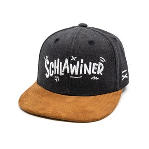 Könnte beinhalten: Eine schwarze und braune Baseballkappe mit dem Wort "SCHLAWINER" in weiß auf der Vorderseite gestickt.