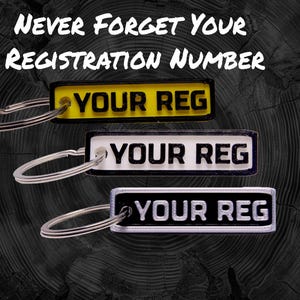 May include: Three keyrings with black and white rectangular tags that say "YOUR REG" in white lettering. The tags are attached to silver key rings. The top tag is yellow, the middle tag is white, and the bottom tag is black.