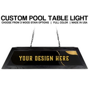 May include: A custom pool table light with a black frame and a black and gold design. The text "YOUR DESIGN HERE" is displayed in gold. The light hangs from chains and includes the text "CUSTOM POOL TABLE LIGHT".