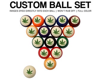 May include: A custom billiard ball set with a cannabis leaf design. The balls are arranged in a triangle, with a single ball at the bottom. The text "CUSTOM BALL SET" is at the top.