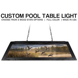 May include: A rectangular pool table light fixture with a black frame and a nature scene featuring flying ducks over a misty lake. The text "CUSTOM POOL TABLE LIGHT" is at the top.