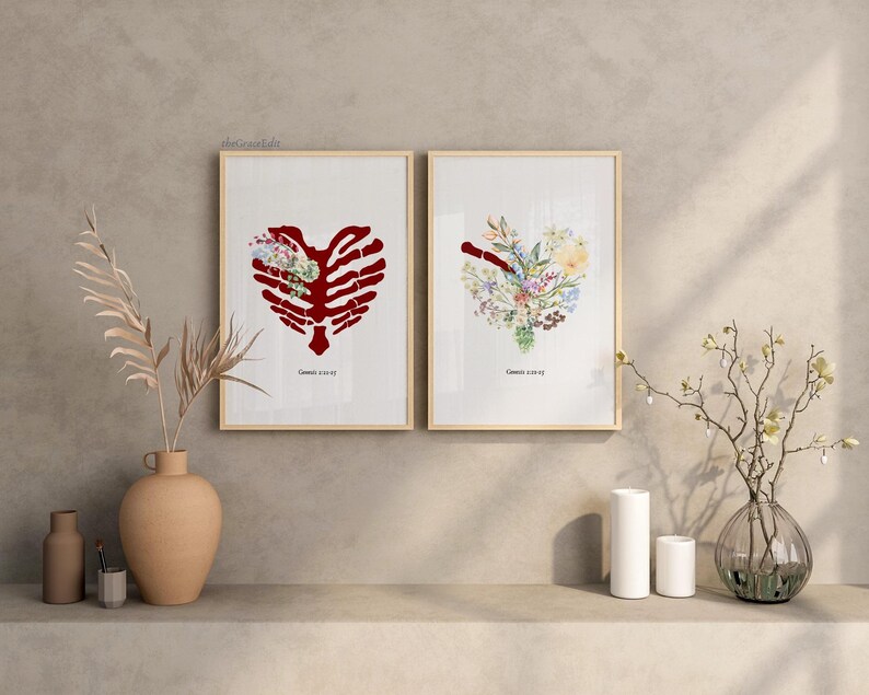 K&ouml;nnte beinhalten: Zwei gerahmte Kunstdrucke. Einer zeigt einen roten Brustkorb in Herzform mit floralen Akzenten. Der andere Druck hat ein herzf&ouml;rmiges Blumenarrangement. Beide Drucke haben einen hellen Holzrahmen und stehen auf einem Regal.