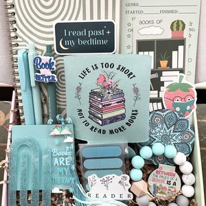 May include: A turquoise-themed gift box for book lovers, containing a notebook, pens, stickers, a bookmark, and a book review sheet. The box includes the text "I read past my bedtime" and "Life is too short not to read more books."