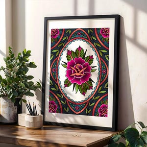 Puede incluir: Impresión artística enmarcada con un diseño de rosa estilo tatuaje. La obra presenta una gran rosa rosa en el centro, rodeada de hojas verdes y un borde adornado con detalles turquesa y coral. La impresión está en un marco negro.