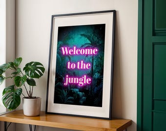 Op de afbeelding: Ingelijste kunstafdruk met een levendige junglescène met palmbomen en weelderig groen in groen- en blauwtinten. De neonroze tekst luidt "Welcome to the jungle". Het kunstwerk wordt gepresenteerd op een houten oppervlak.