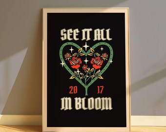 May include: A framed art print with a black background features the text "SEE IT ALL" above a green heart-shaped design with red roses and the words "IN BLOOM" below. The numbers "20" and "17" are also included.