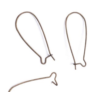 May include: Three gold-toned earring hooks, each with a loop at the top and a small hook at the bottom. The hooks are designed to be used with other jewelry components.