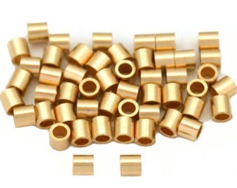 May include: A pile of gold-colored metal jump rings. The rings are small and round, with a hole in the center. There are three additional rings in the bottom right corner of the image.