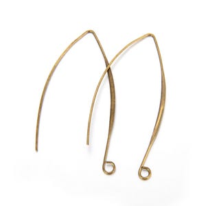 Pode incluir: Um par de brincos de fio dourado com forma curva.
