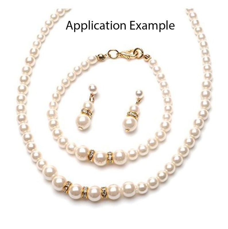May include: A set of white pearl jewelry with gold accents, including a necklace, bracelet, and earrings. The necklace and bracelet have a single row of pearls, while the earrings have a single pearl drop with a gold accent.