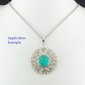 Puede incluir: Un collar de cadena de plata con un colgante de piedra turquesa. El colgante est&aacute; rodeado por un dise&ntilde;o de filigrana de plata con diamantes de imitaci&oacute;n transparentes.