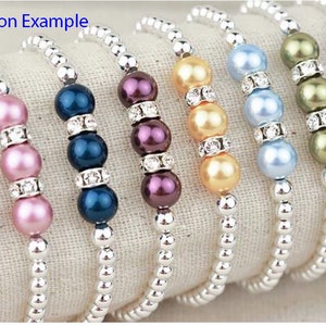 May include: A set of six bracelets with silver chain and pearl beads in various colors, including lavender, pink, blue, purple, gold, and green.