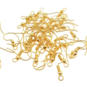 May include: A pile of gold-toned earring hooks with a spring-loaded closure. The hooks are made of metal and have a small ball at the top.