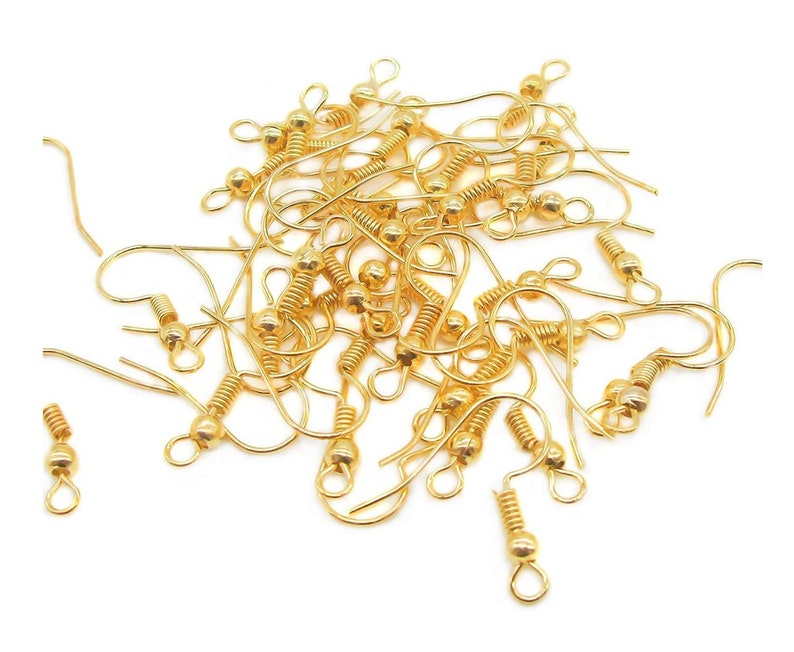 May include: A pile of gold-toned earring hooks with a spring-loaded closure. The hooks are made of metal and have a small ball at the top.