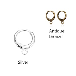 May include: Two pairs of earring findings, one pair in silver and one pair in antique bronze. The silver findings are shown individually, while the bronze findings are shown as a pair.