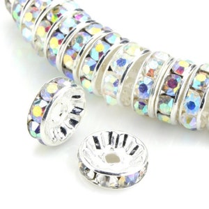 May include: Silver-toned spacer beads with iridescent rhinestones. The beads are round and have a flat back. They are perfect for adding a touch of sparkle to jewelry.