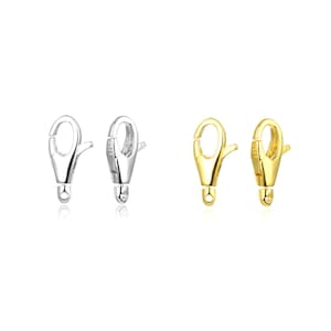 May include: Two silver and two gold lobster claw clasps for jewelry making. The clasps are about 1 inch long.