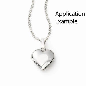 Puede incluir: Un medall&oacute;n de plata en forma de coraz&oacute;n en una cadena de plata. El medall&oacute;n est&aacute; cerrado y tiene una superficie lisa. La cadena es delicada y de estilo curb.