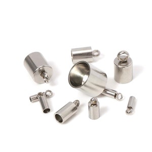 May include: A collection of shiny, silver-colored metal jewelry findings, including cylindrical end caps with loops, a tube with a loop, and a cone-shaped piece. These components are used for jewelry making and crafting.