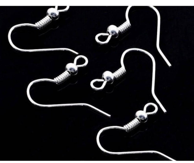 May include: Five silver earring hooks with a spring coil and a small ball at the top.