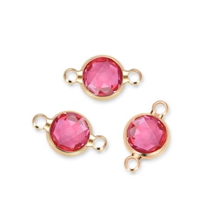 May include: Three gold-tone connector charms with pink faceted glass stones. Each charm has two loops for attaching to jewelry.