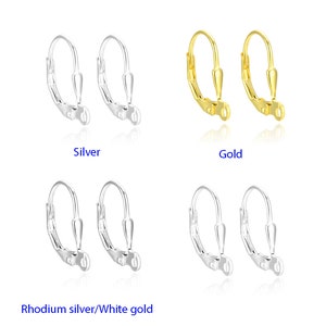 May include: Three pairs of earring hooks in silver, gold, and rhodium silver. The hooks are made of metal and have a simple design.