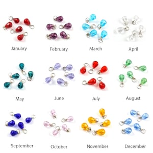 May include: A selection of teardrop-shaped crystal beads in various colours, each attached to a small silver ring. The image is divided into sections, each labelled with a month from January to December.