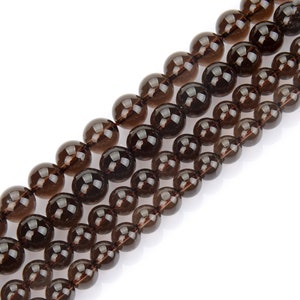 May include: A strand of dark brown smoky quartz beads. The beads are round and smooth, and they are strung on a clear thread.