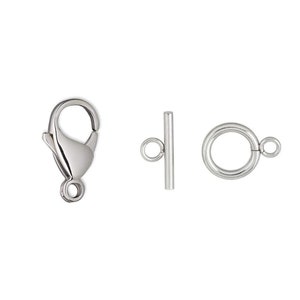 May include: Three silver metal jewelry clasps: a lobster claw clasp, a toggle clasp, and a ring clasp.
