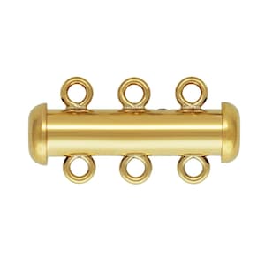 May include: A gold-colored, three-strand jewelry clasp. The clasp is cylindrical with six small loops for attaching jewelry strands. The ends of the clasp are rounded. The metal has a shiny finish.