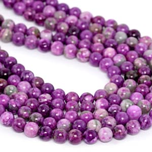 May include: A strand of purple agate beads with a marbled pattern. The beads are round and smooth, and they are strung on a clear thread.