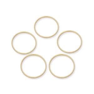 May include: Five gold-colored metal jump rings. The rings are all the same size and are arranged in a circle.