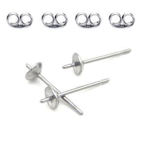 May include: A collection of silver-colored earring posts and backs. The posts have a flat, round disc at the front and a small post at the back. The earring backs are butterfly style, with a curved design.