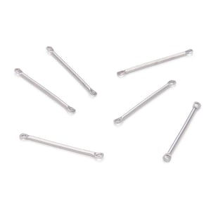 May include: Six silver metal jump rings with open loops at each end. The rings are approximately 1 inch long.