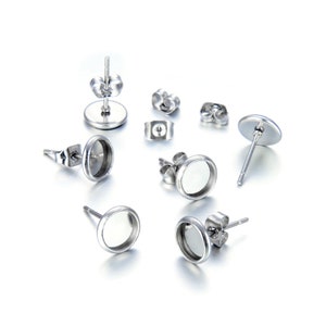 May include: Six silver earring settings with round bezels. The bezels are empty and ready to be filled with a cabochon.