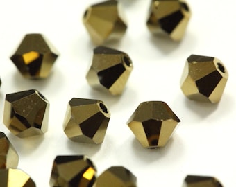 May include: A group of gold-toned faceted glass beads. The beads are small and have a hole in the center for stringing.